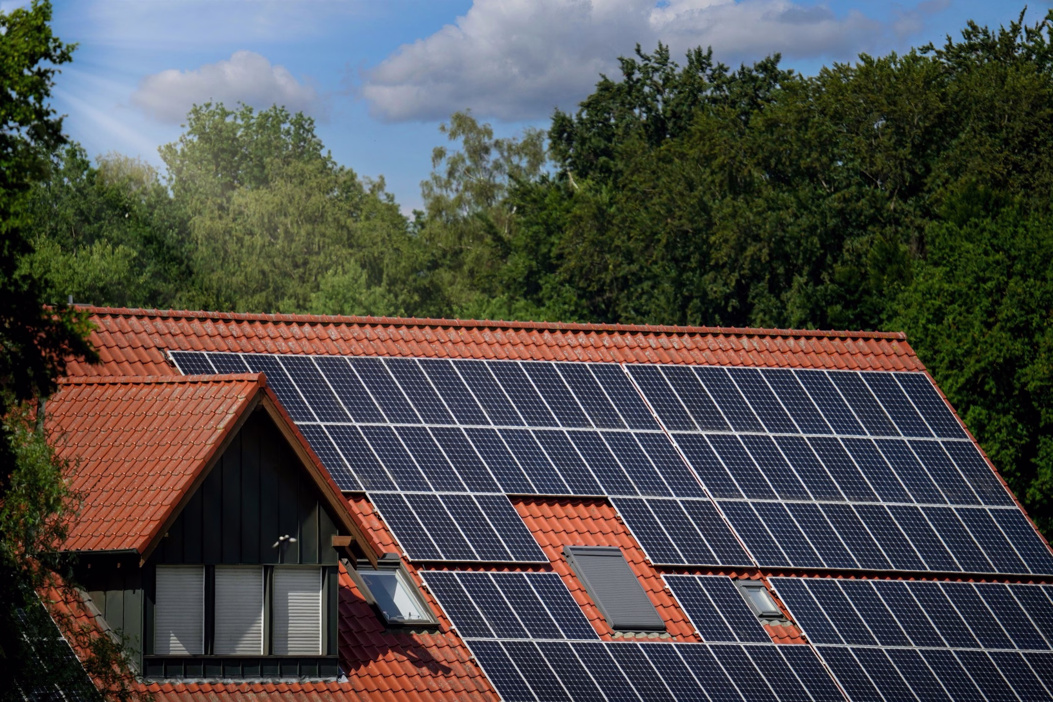 A closeup shot of a modern light brown roof covered with dark blue solar panels